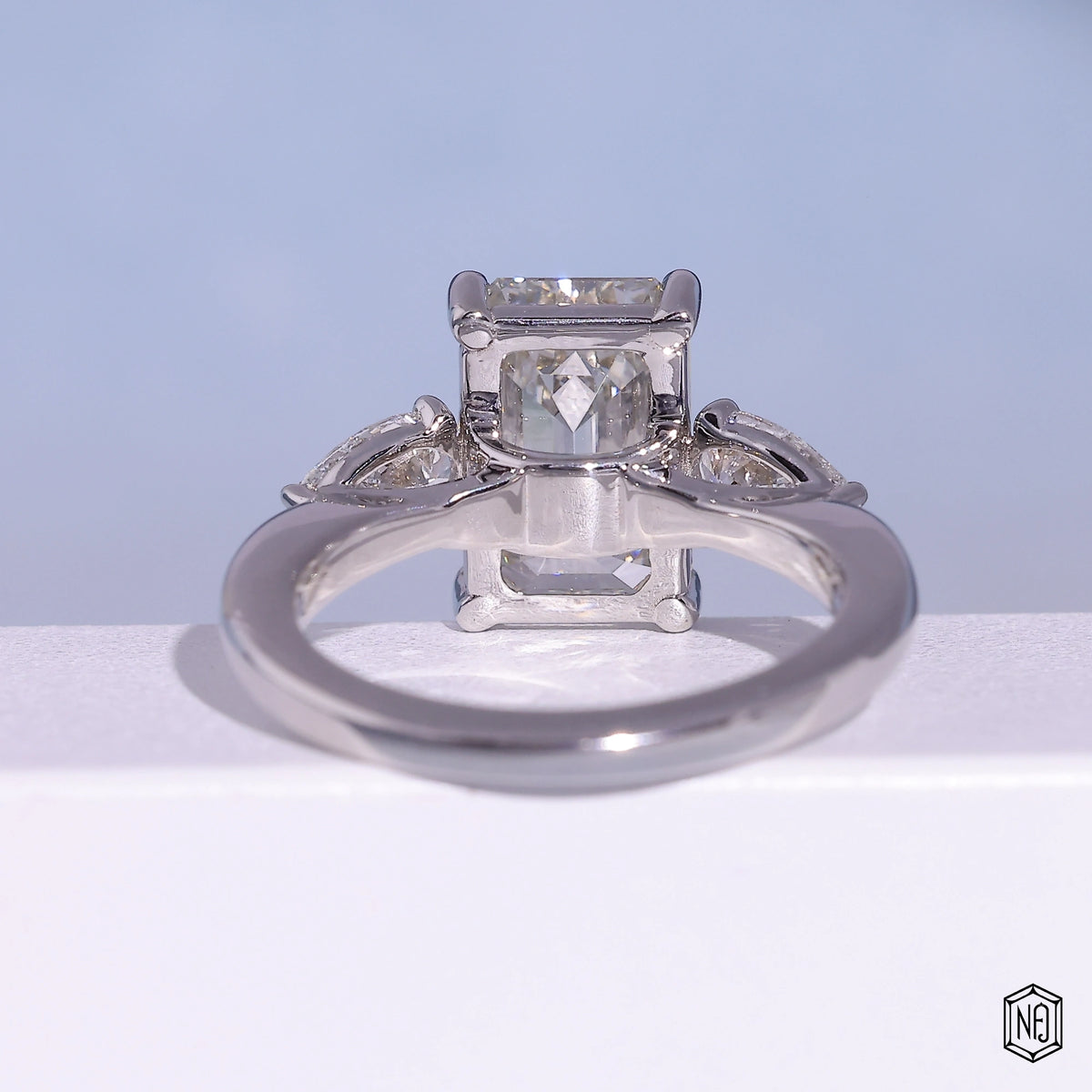 4.71 Carat Emerald Cut Lab Grown Diamond Trellis Three-Stone Engagement Ring - Hand View / Detail Angle