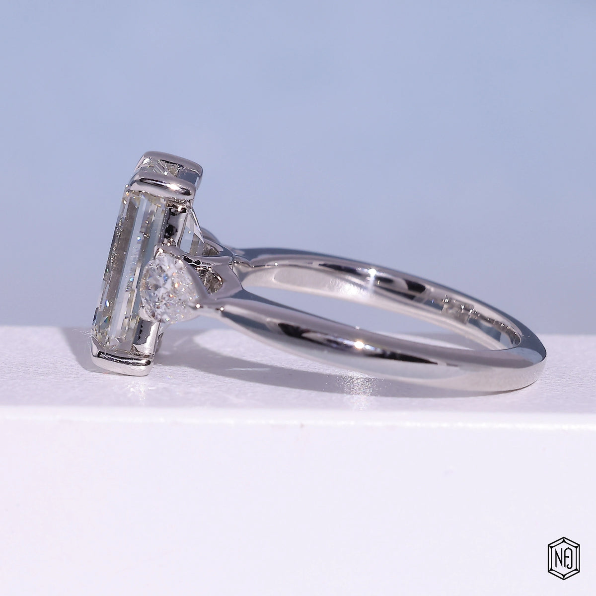 4.71 Carat Emerald Cut Lab Grown Diamond Trellis Three-Stone Engagement Ring - Angled Perspective